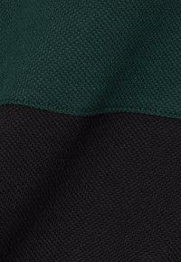 Breikatoen in donkergroen en zwart, met contrasterende horizontale banden, een gladde textuur en een strakke weefpatroon. Geen opmerkelijke hardware.