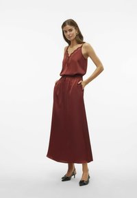 Satin maxi-jurk in diep bordeauxrood met kantafwerking, verstelbare banden, gathered tailleband en zijzakken. Gemaakt in combinatie met zwarte slingback-schoenen.