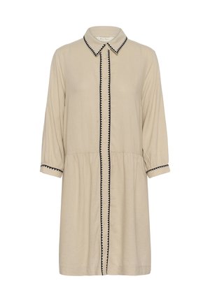 Beige knee-length dress with long sleeves, button front, pointed collar, and black zigzag trim on collar, button line, and cuffs.