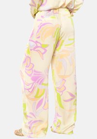 Lichte, pastelgekleurde broeken met grote bloempatronen in roze, geel en groen. Voorzien van een elastische tailleband en een wijde pijpdesign.