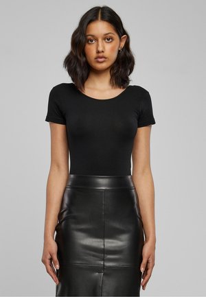 Must lühikeste varrukatega bodi, mis on ühendatud kõrge vöökohaga musta nahast pliiatsseelikuga. Sile tekstuur, figureeritav disain ja ümmargune kaelus.