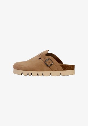 Chaussure à sabot en daim beige avec une boucle sur le côté, semelle de plate-forme texturée et accent en liège au talon. Vue latérale mettant en avant la forme et le design.