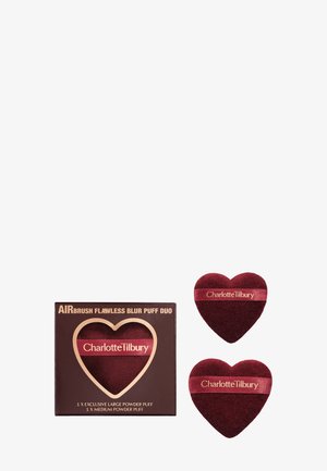 Zwei herzförmige, burgunderrote Makeup-Pads und passende Verpackung mit der Aufschrift Charlotte Tilbury.