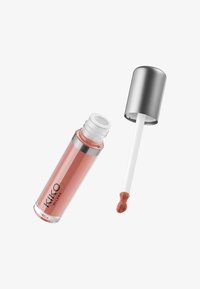 Glanset fersken-rosa leppestift tube med sølvkork fjernet, viser applikatorstav med en liten mengde produkt på hvit bakgrunn.