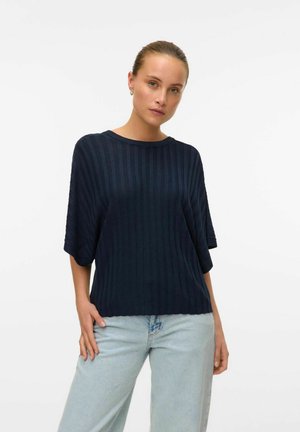 Navy blue ribbed knit top with a round neckline, short sleeves, and a relaxed fit, paired with light blue jeans.
