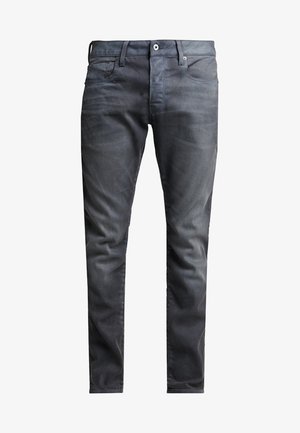Jeans de ganga escura com um corte slim, apresentando cinco bolsos, fecho de botão e desbotamento subtil para textura.
