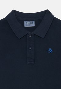 Marineblaues Poloshirt aus strukturiertem Stoff, mit einem Kragen, zwei schwarzen Knöpfen und einem kleinen blauen gestickten Logo.