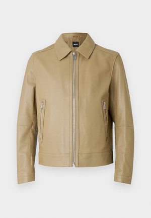 Kurtka ze skóry w kolorze brązowym z kołnierzem, przednim zamkiem błyskawicznym i dwoma zamykanymi na zamek kieszeniami po bokach. Gładka faktura i dopasowany krój.