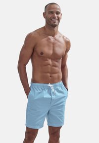 Light blue swim shorts made from a soft material, featuring an elastic waistband with a white drawstring and side pockets.