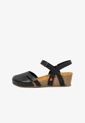Zwarte leren damessandaal met sleehak, gesloten neus, enkelbandje en een beige kurken zool met een klein oranje bloemenlogo aan de zijkant.