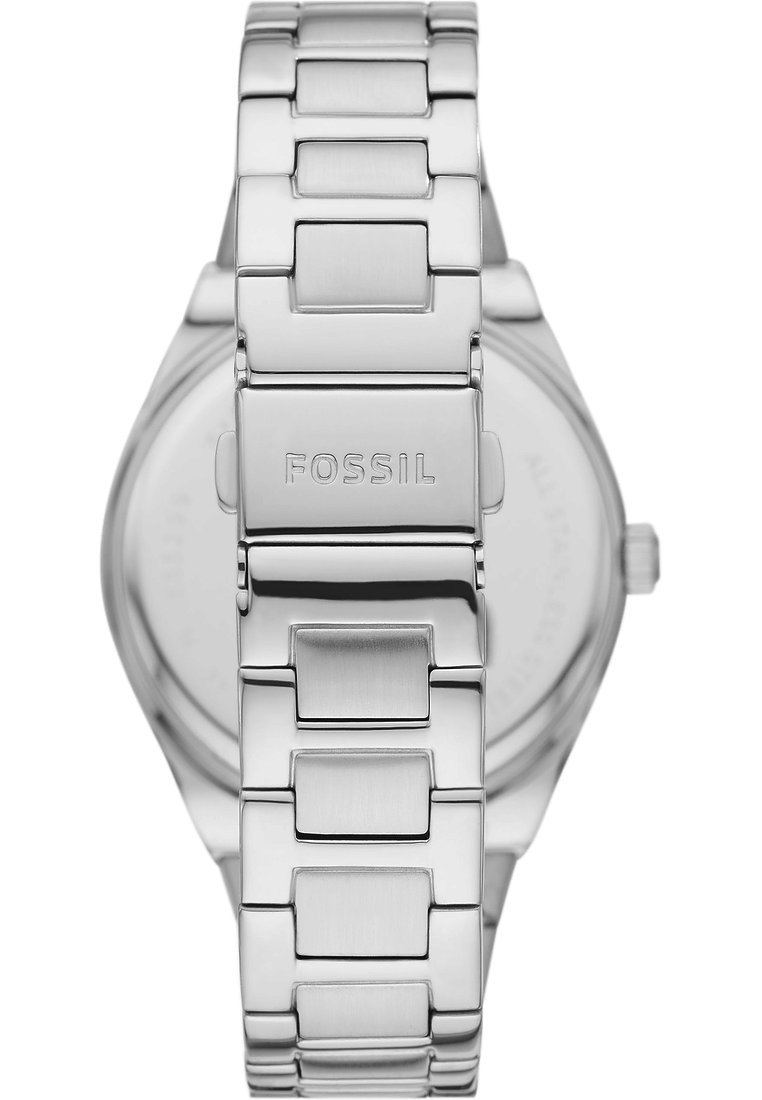 Montre en métal argenté avec un bracelet à maillons, présentant une finition polie et un cadran rond lisse. La marque "FOSSIL" est gravée sur le fermoir.