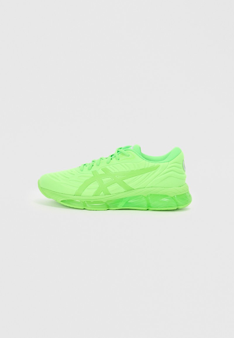 Grüne Sportschuhe mit einer strukturierten Oberseite, Schnürsenkeln und transparenter Sohle. Verfügt über eine markante Markenkennzeichnung an der Ferse und seitlich.