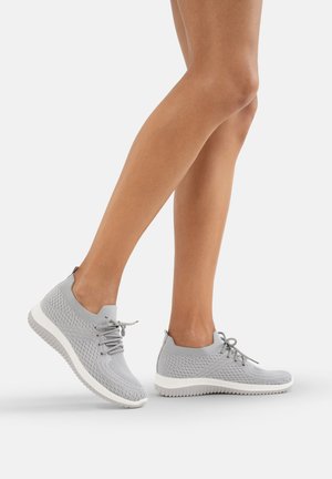 Sneakers a maglia grigia chiara con texture traspirante, design con lacci e suola in gomma bianca. Presentano una vestibilità aderente attorno alla caviglia.
