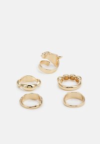 Conjunto de cinco anéis de ouro. Apresenta designs variados: liso, torcido, um padrão de contas e uma forma divertida de animal. Brilho metálico em toda a peça.