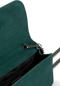 Turkusowa zamszowa torebka na ramię z łańcuszkowym paskiem, z zapięciem magnetycznym i czarną wyściółką. Wnętrze zawiera kieszonki na karty.