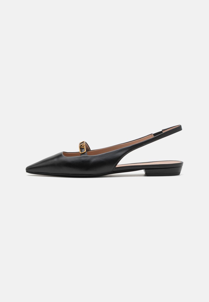 Sort læderslingback-sko med spids tå, lille gul accent nær hælen og flad sål. Glat tekstur og minimal design.