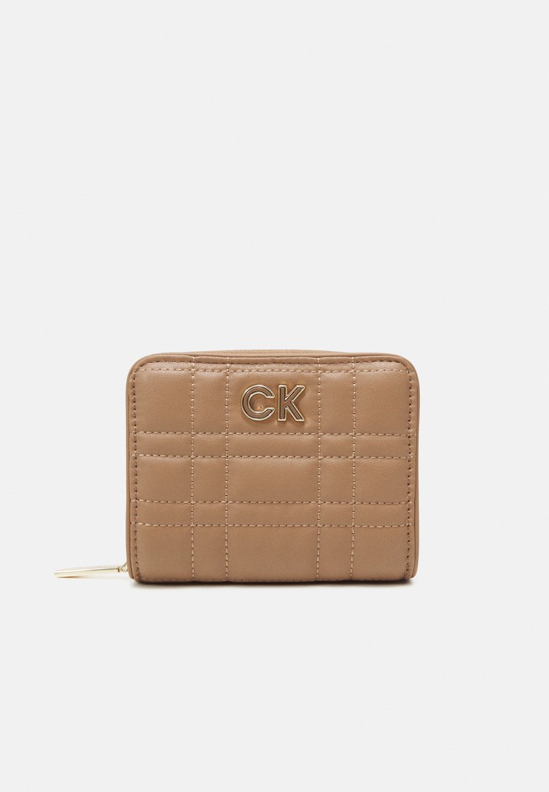 Rudas siuvinėtas piniginė su auksiniu iškilmingu "CK" logotipu. Lygus paviršius, užtrauktuko uždarymas ir daugiakompartis dizainas kortelėms ir monetoms.