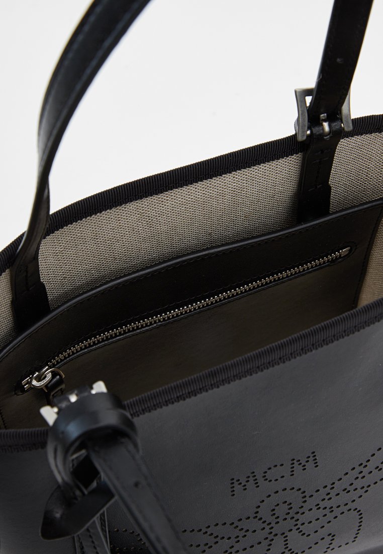 Schwarze Lederhandtasche mit durchstochenem Logo, oberer Reißverschluss-Tasche und strukturiertem Innenraum. Verfügt über robuste schwarze Riemen und kontrastierendes beiges Innenfutter.