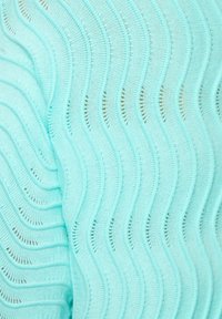 Tissu tricoté turquoise clair avec un motif ondulé alternant mailles ouvertes et fermées, créant texture et profondeur.