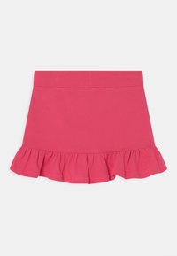 Rosa bomullskjol med volangkant. Har ett elastiskt midjeband och en mjuk textur. Enkel design utan ytterligare mönster eller detaljer.