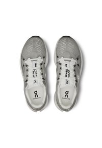 Baskets de sport grises avec une tige en mesh, lacets blancs et logo. Comprend une languette et un col rembourrés, une semelle légère et des détails texturés.