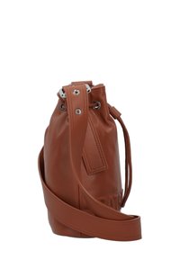 Braune Leder-Eimer-Tasche mit Kordelzugverschluss, silbernen Ösen, verstellbarem Tragegurt und geprägten Details auf der Vorderseite.