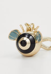 Bee-shaped charm in gold-tone metal with black and cream spiral body, transparent blue wings, and a clip attachment for keys or bags.