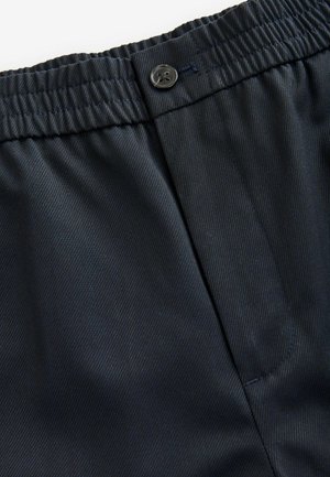 Navy blue, lightweight fabric with a smooth texture. Features an elastic waistband with a button closure and a single side pocket.