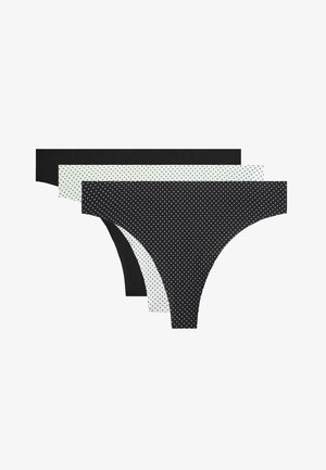 Tre mutande da donna stile bikini in nero solido, bianco con puntini neri e nero con puntini bianchi, disposte sovrapposte su sfondo bianco.