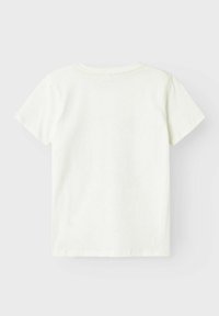 Camiseta blanca de manga corta con cuello redondo, hecha de una suave tela de algodón. Sin patrones ni gráficos visibles, diseño simple y liso.