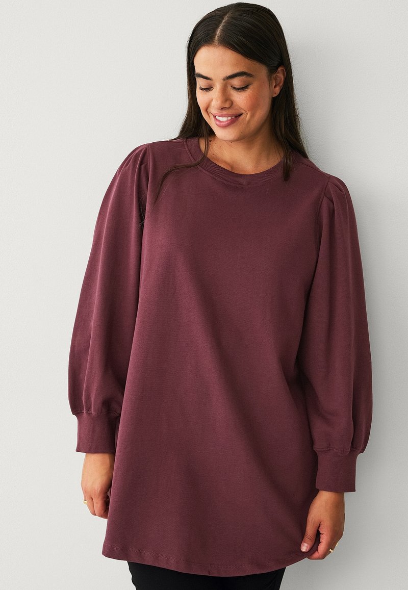 Bordeaux pullover met lange pofmouwen, ronde halslijn en zachte, textuurstof. Losse pasvorm en knielange ontwerp.