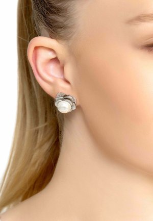 Silver earrings featuring a textured floral design with a large white pearl center and small diamond-like accents.