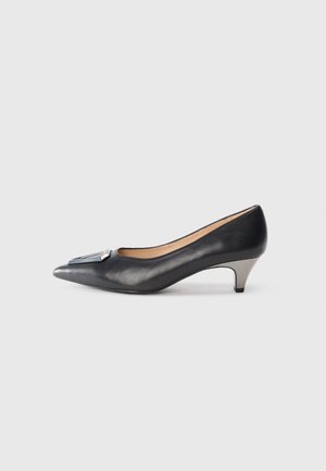 Décolleté in pelle nera con punta affusolata e un accento metallico sulla tomaia. Presenta un tacco basso e curvo e una texture liscia.