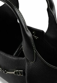 Borsa a tracolla in pelle nera con finitura testurizzata, ferrature argentate e cuciture bianche a contrasto. La parte superiore aperta rivela un interno spazioso.