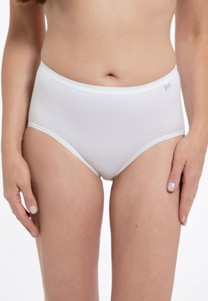 Woman wearing plain white high-waisted brief underwear, standing with arms relaxed by her sides against a white background.