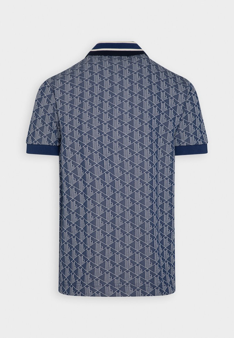 Marineblauwe polo met een gestructureerd geometrisch patroon, contrasterende kraag en mouwboorden in donkerblauw, korte mouwen en een klassieke pasvorm.