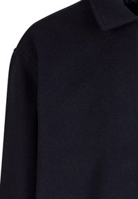 Black collared shirt with a smooth texture, featuring a simple design and straight cut, showing minimal stitching and no visible hardware.