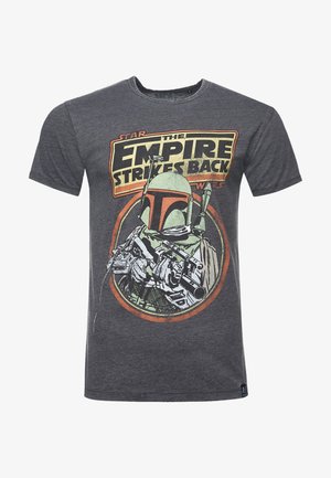 T-shirt grigia in cotone con una grafica colorata di un personaggio con casco e blaster, testo che recita "L'Impero colpisce ancora."