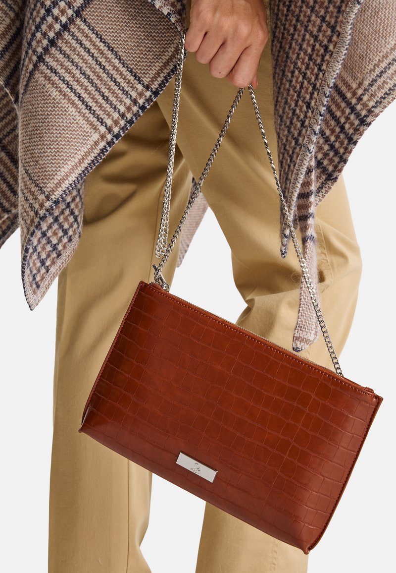 Borsa a tracolla in pelle marrone con embossing a forma di coccodrillo, forma rettangolare e una placca metallica con logo sulla parte anteriore.