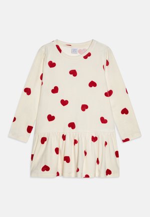 Cream long-sleeve dress with gathered skirt, decorated with scattered red heart patterns.