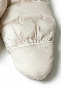 Mitaine rembourrée beige clair présentant un motif géométrique de petits triangles blancs, avec un tissu froncé au niveau du poignet pour un ajustement confortable.