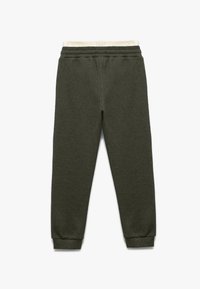 Gröna stickade sweatpants med texturerad finish, elastisk midja och ribbade manschetter. Bakre vy visar en enkel, strömlinjeformad design.