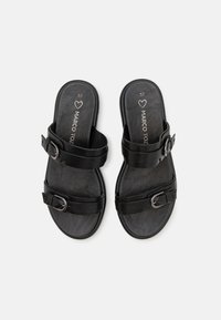 Zwarte schuursandalen met twee verstelbare banden met metalen gespen, gemaakt van glad kunstleer en een gegroefd voetbed voor comfort.