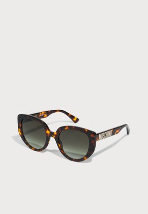 Óculos de sol estilo gato com um padrão tartaruga, lentes cinzentas e um logótipo branco na haste. Armação em plástico elegante com acabamento brilhante.