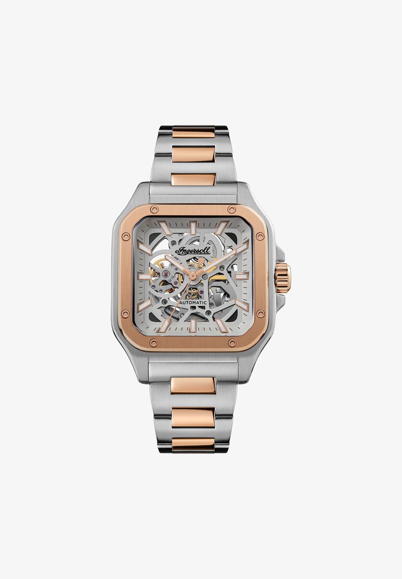Vierkante horloge met zilveren roestvrij staal en roségouden accenten. Skeleton wijzerplaat onthult de beweging. Geborstelde en gepolijste schakelarmband.