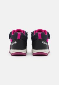 Une paire de baskets noires et roses pour enfants vues de l'arrière, dotées de semelles blanches et du logo PRIMIGI sur le talon.