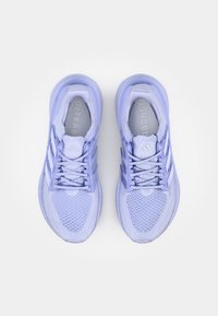 Ett par ljuslila löparskor med nätmönster, snörena knutna och vita ränder på sidorna, sedda uppifrån på vit bakgrund.