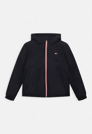 Veste noire à capuche avec fermeture éclair frontale ornée de bordures rouges, blanches et bleues et petit logo rectangulaire sur la poitrine, poignets élastiques et poches latérales.