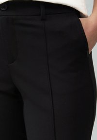 Zwarte op maat gemaakte broek met een gladde textuur, voorzien van een zijzak, riemlussen en een knoopsluiting op de taille.