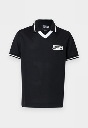 Zwart polo-shirt met korte mouwen en witte rand aan de kraag en mouwen, met een "Versace Jeans Couture" logo-patch op de borst.